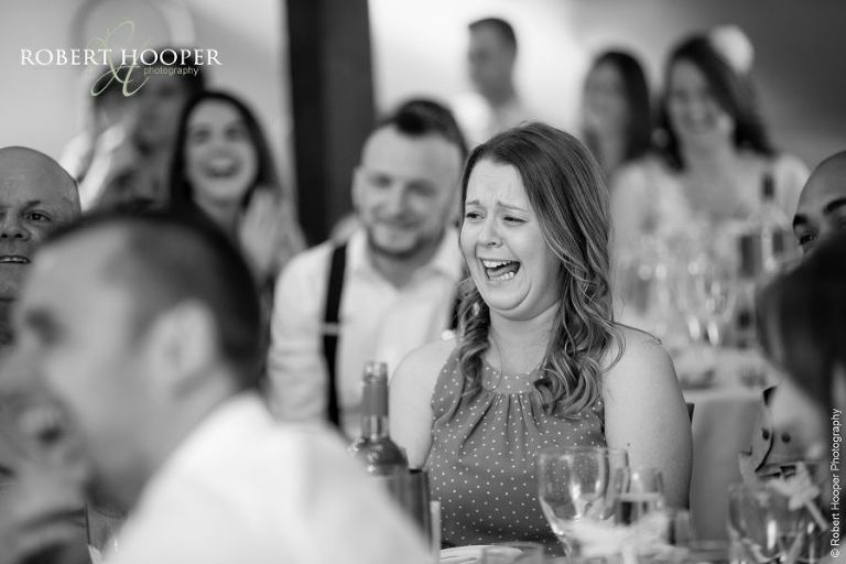 Wedding guests laughing at funny speeches at Oaks Farm Barn wedding Surrey