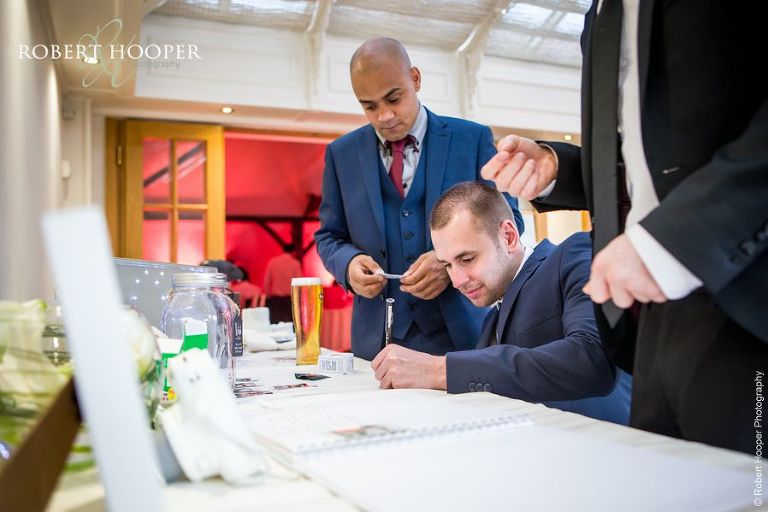 Wedding guests leaving wishes for wish jar at wedding reception at Oaks Farm Barn Shirley Surrey