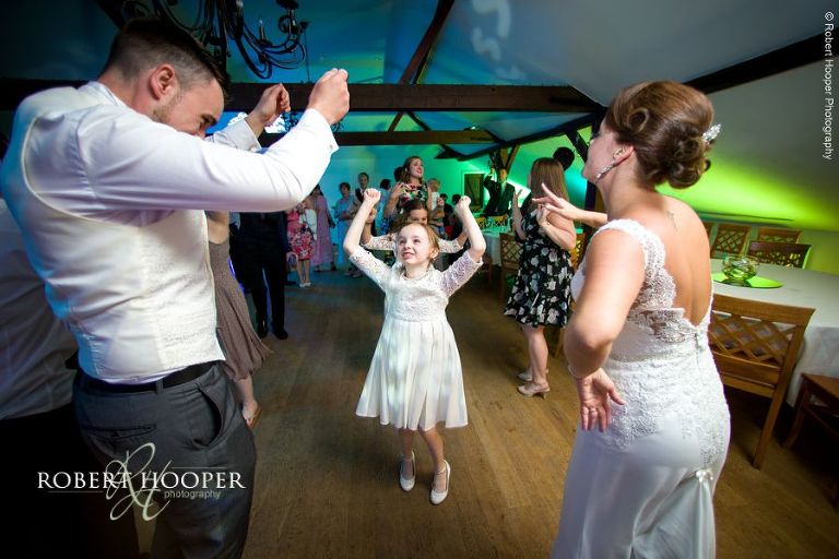 Newlyweds dance with the flower girl after their first dance at Oaks Farm Barn Shirley Surrey