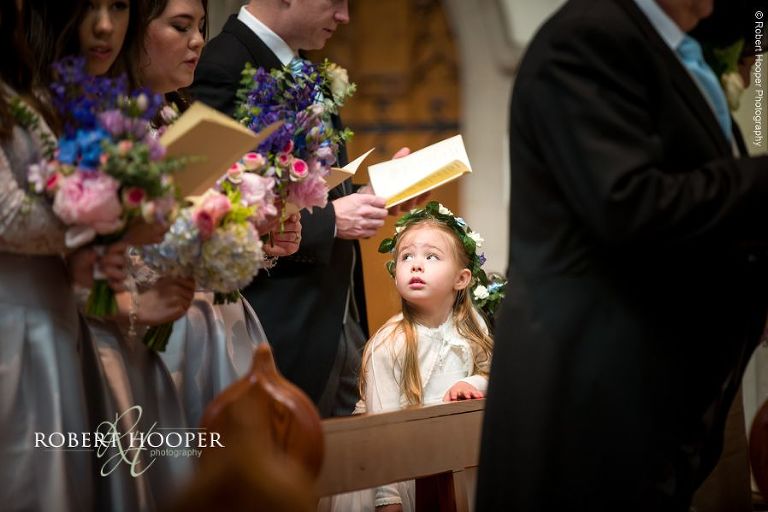 Flower girl during carol singing at wedding at Sacred Heart Church Wimbledon