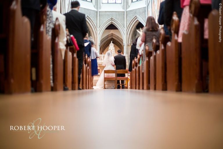 Bride and groom at the alter during wedding service at Sacred Heart Church Wimbledon London