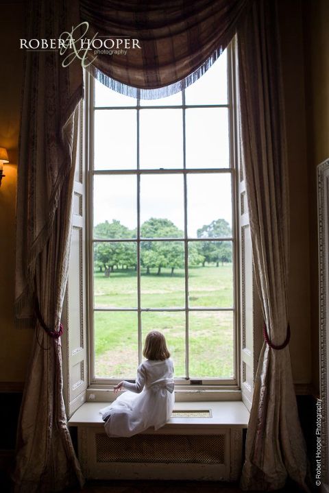 Flower girl looking out at deer during wedding reception at Hampton Court House Surrey