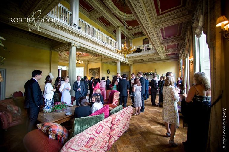 Wedding guests mingling during champagne and canapes reception at Hampton Court House Surrey