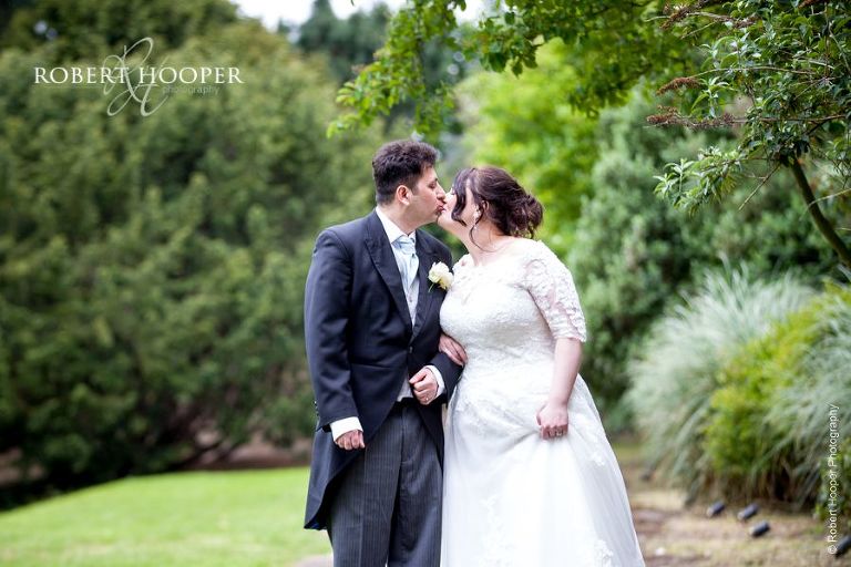 Bride and groom kiss on wedding day at Hampton Court House Surrey