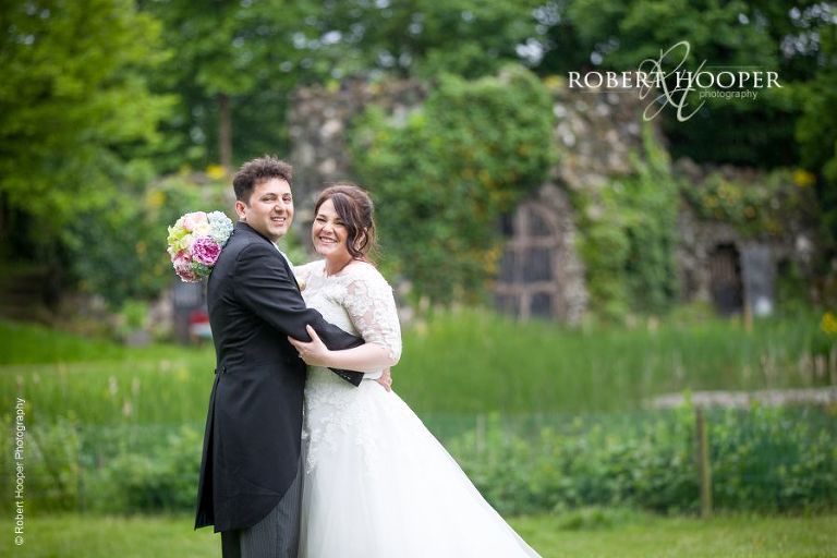 Bride and groom hug on their wedding day at Hampton Court House Surrey