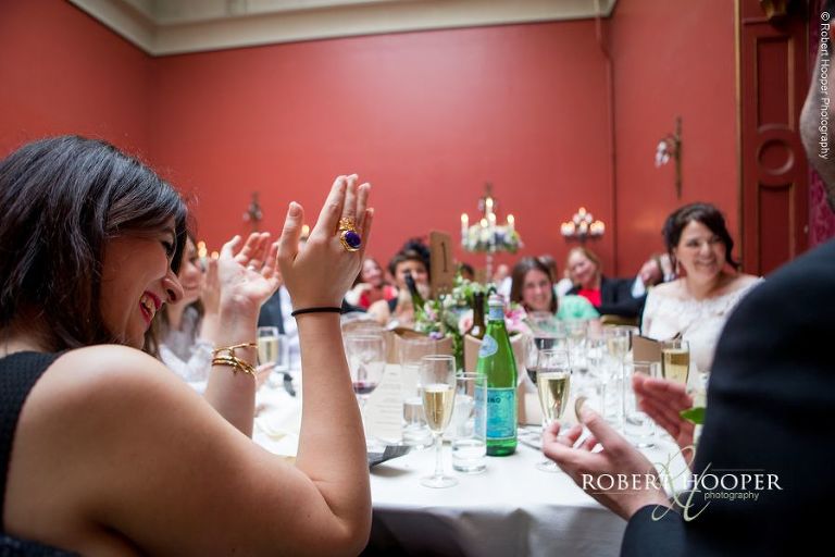 Guests clap groom's speech after wedding breakfast at Hampton Court House Surrey