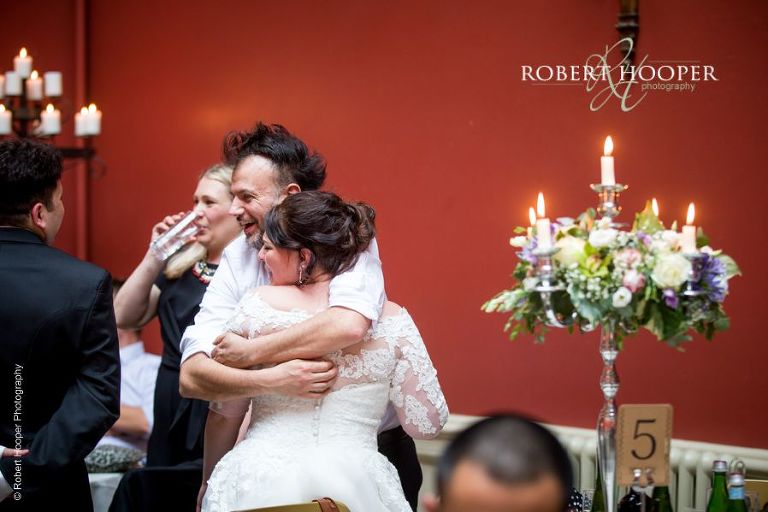Bride hugs guests during wedding breakfast at Hampton Court House Surrey