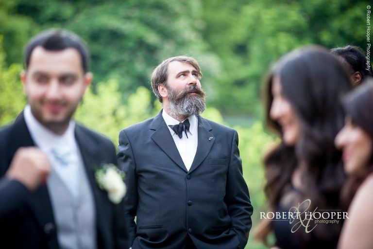 Wedding guest outside in the gardens of Hampton Court House Surrey before evening reception commences
