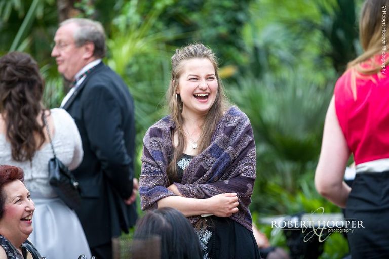 Wedding guest outside in the gardens of Hampton Court House Surrey before evening reception commences
