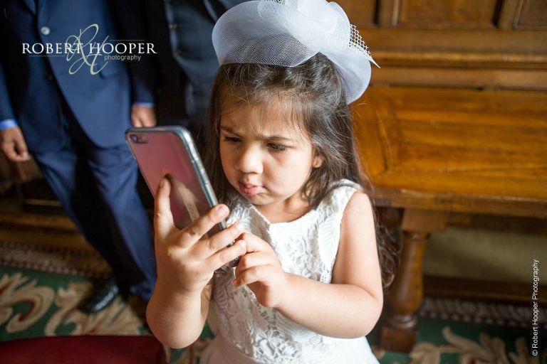 Young wedding guest on Dad's iPhone at Hindu wedding ceremony at Middle Temple London