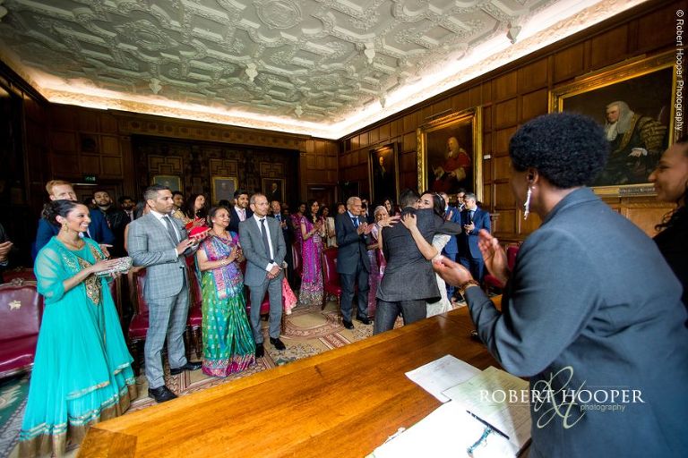 Bride and groom hug after being announced man and wife at legal ceremony at Middle Temple London