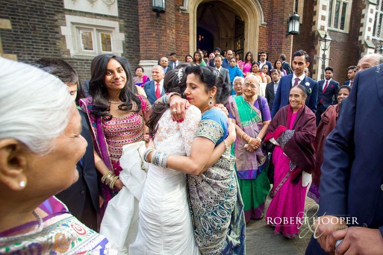 Bride hugs wedding guests goodbye before leaving with her groom in horse and cart at Middle Temple London