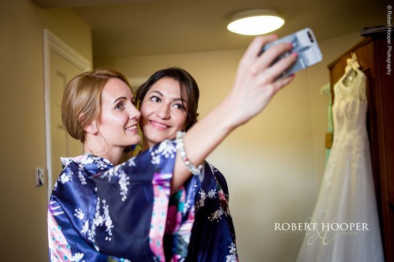 Bridesmaids take a selfie after make-up for wedding day at Wotton House Dorking Surrey