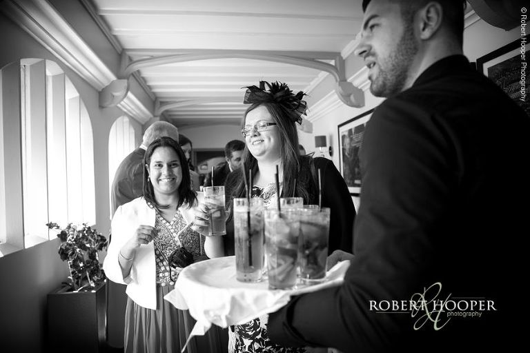 Guests being served Pimms at wedding reception at Wotton House Dorking Surrey