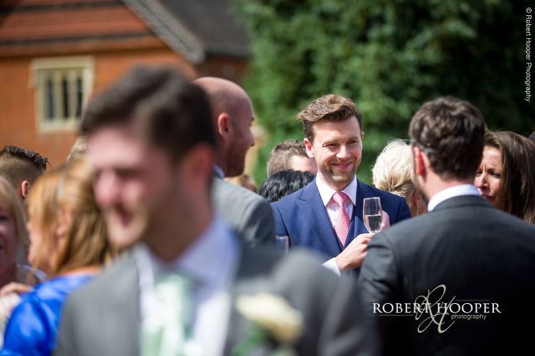 Wedding guest enjoying champagne at wedding reception at Wotton House Dorking Surrey