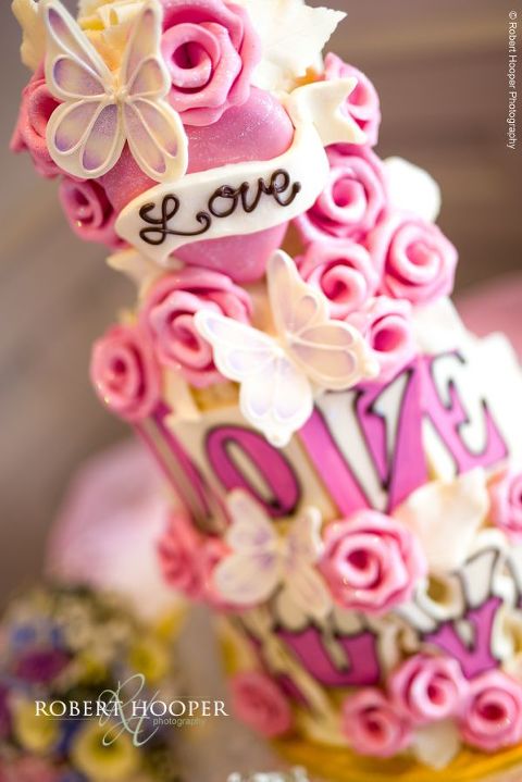 Choccywoccydoodah pink and white rose and butterfly wedding cake with love written on front in milk chocolate for wedding day at Wotton House Dorking Surrey