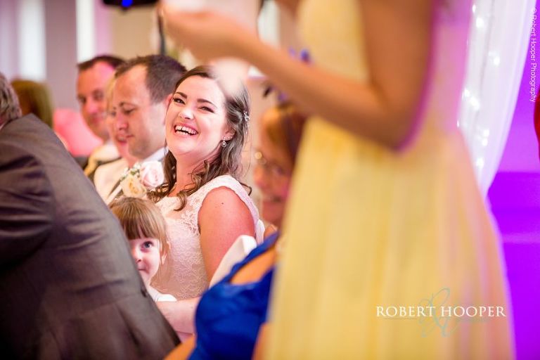 Bride laughing at bridesmaid speech during wedding breakfast at Wotton House Surrey