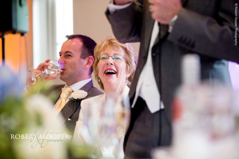 Mother of the bride laughing at Groom's speech during wedding breakfast speeches at Wotton House Dorking Surrey