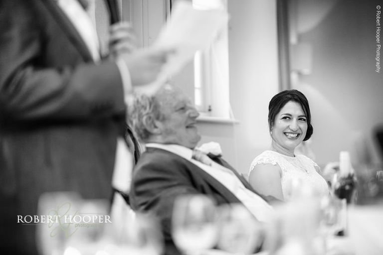 Bridesmaid on top table laughing at groom's speech at Wotton House Dorking Surrey