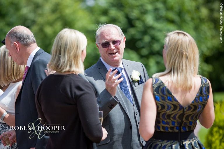 Wedding guests enjoying champagne reception on wedding day at Chilston Park Hotel Maidstone Kent