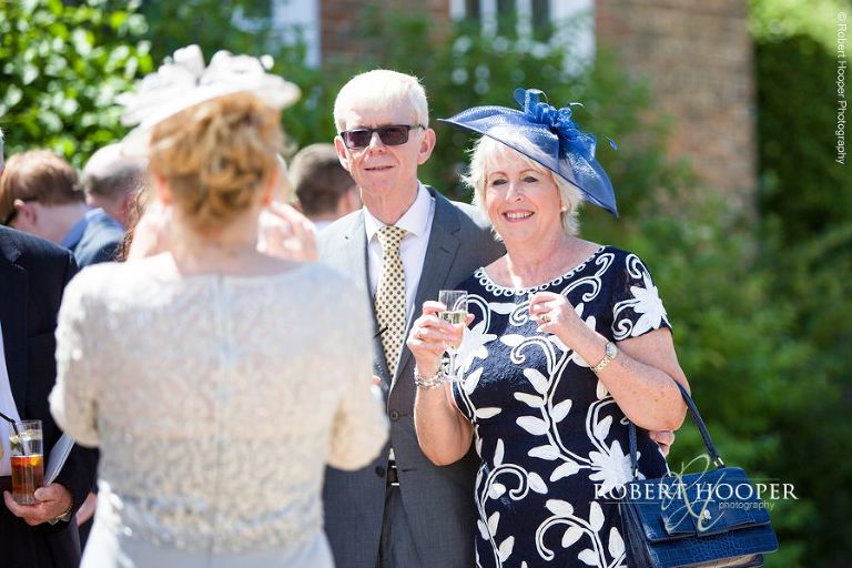Wedding guests enjoying champagne reception on wedding day at Chilston Park Hotel Maidstone Kent