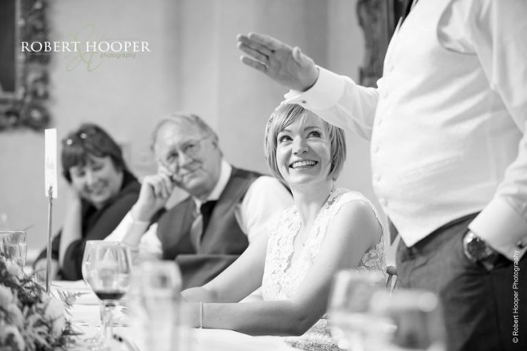 Bride laughing at groom's speech on wedding day at Chilston Park Maidstone Kent