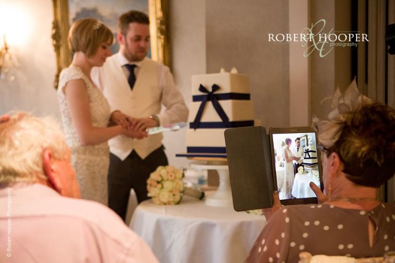 Bride and groom cut the cake at wedding breakfast at Chilston Park Maidstone Kent
