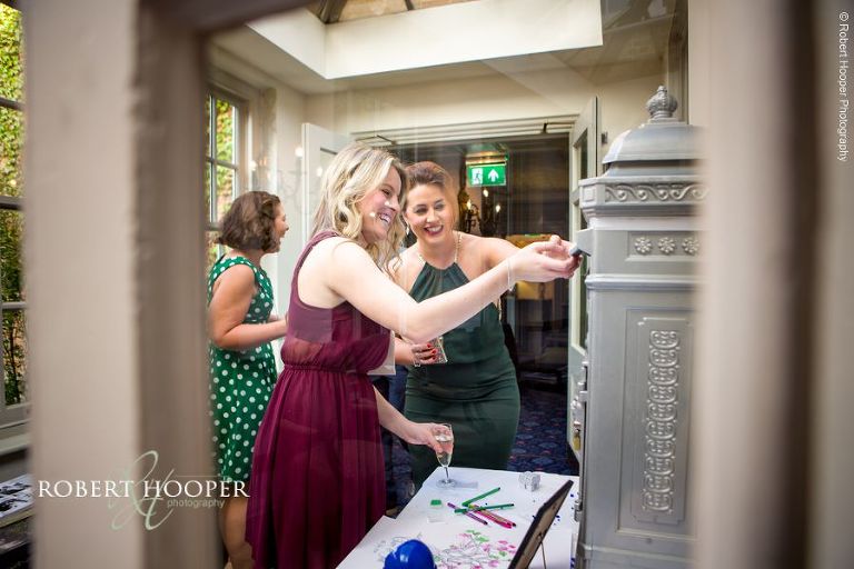 Wedding guests posting cards in letter post box on wedding day at Chilston Park Maidstone Kent