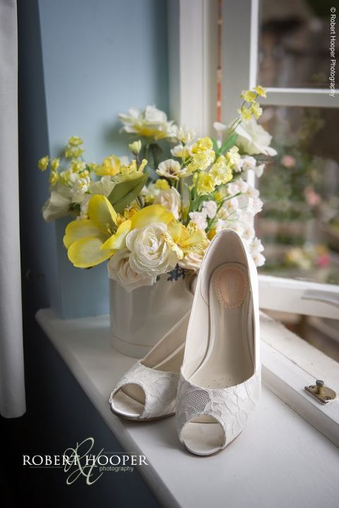 Bride's shoes with white lace detail on window sill on wedding day in Henley-on-Thames Oxfordshire