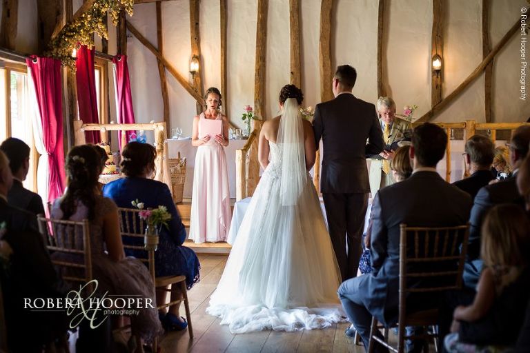 Bridesmaid gives reading at civil wedding ceremony in the barn at The Crown Inn Pishill Oxfordshire