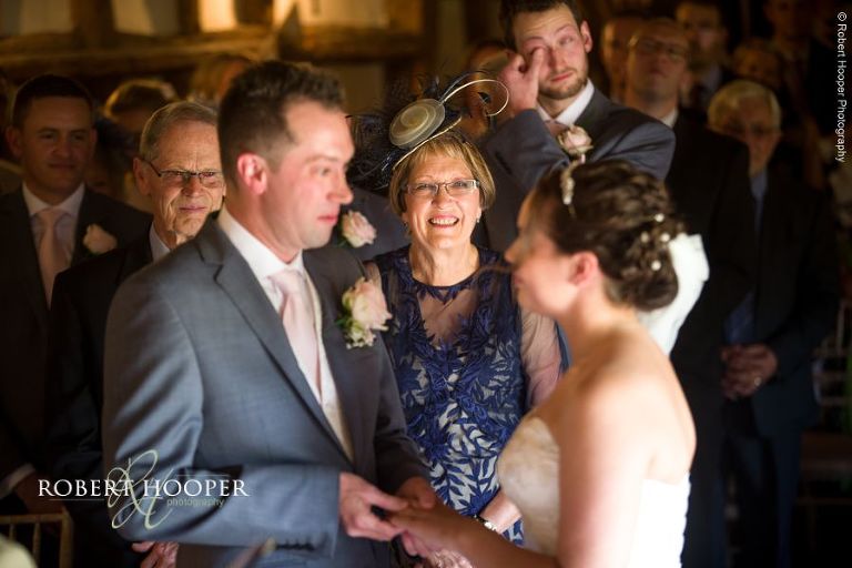 Bride and groom exchange rings during civil wedding ceremony in the barn at The Crown Inn Pishill Oxfordshire