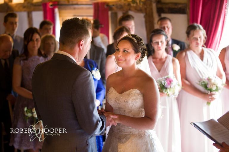 Bride and groom exchange rings during civil wedding ceremony in the barn at The Crown Inn Pishill Oxfordshire
