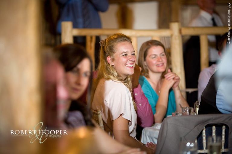 Wedding guests laughing at speeches during wedding breakfast at The Crown Inn Pishill Oxfordshire