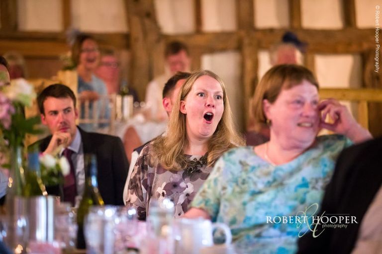 Wedding guests laughing at speeches during wedding breakfast at The Crown Inn Pishill Oxfordshire