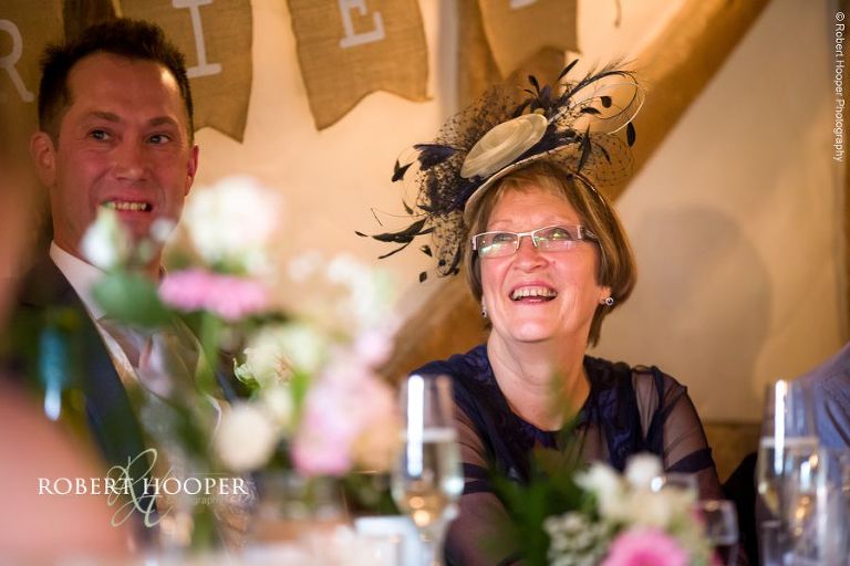 Wedding guests laughing at speeches during wedding breakfast at The Crown Inn Pishill Oxfordshire