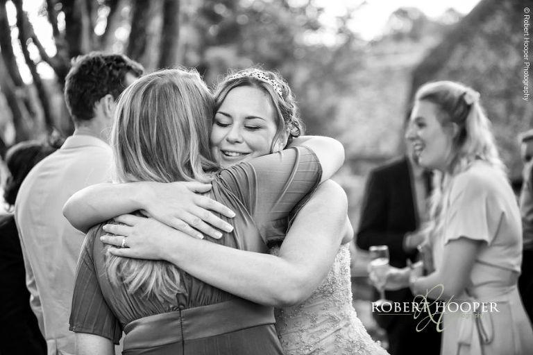 Bride hugging friends as they arrive for party on wedding day at The Crown Inn Pishill Oxfordshire