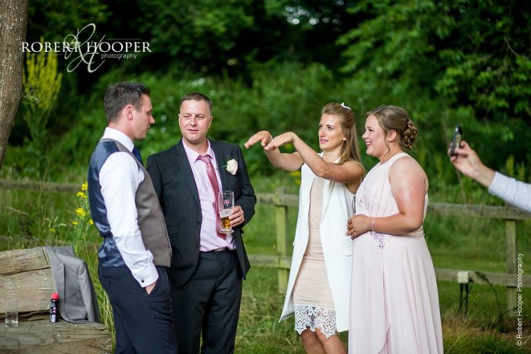 Wedding guests on the back lawn whilst room is turned around for evening party on wedding day at The Crown Inn Pishill Oxfordshire