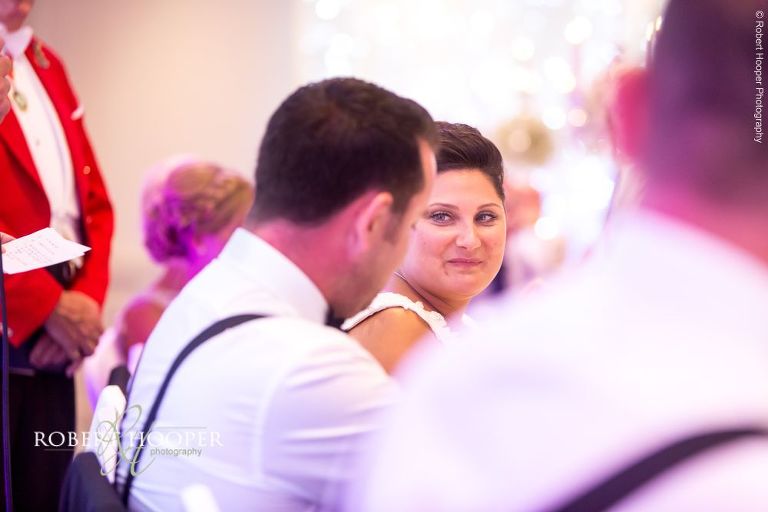 Bride laughing at dad's speech during wedding breakfast at Wotton House Dorking Surrey