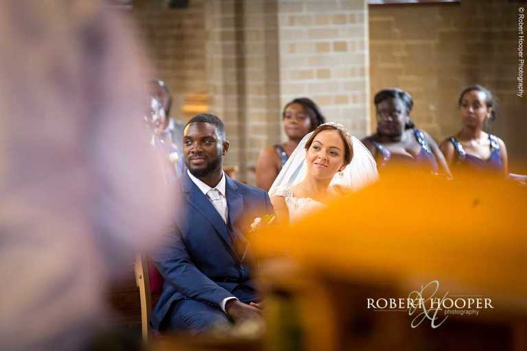 Bride and groom listening to reader during their wedding ceremony at St John The Divine Church South Croydon Surrey