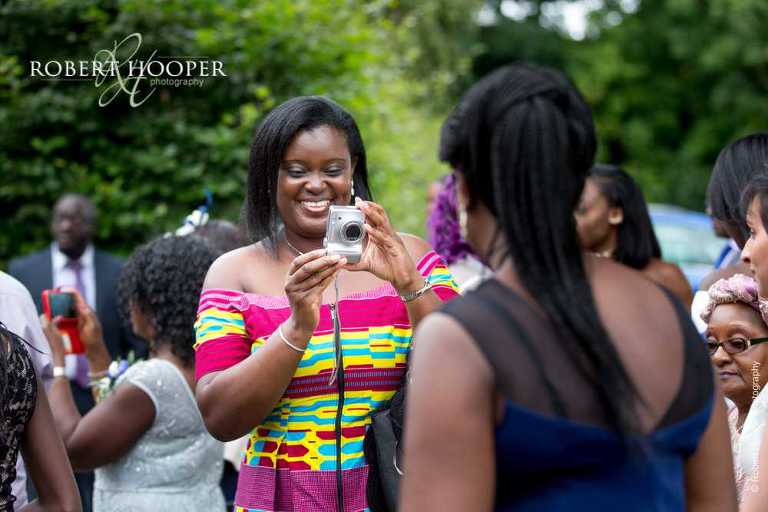 Wedding guests taking photos of each other after ceremony at St John the Divine Church South Croydon Surrey