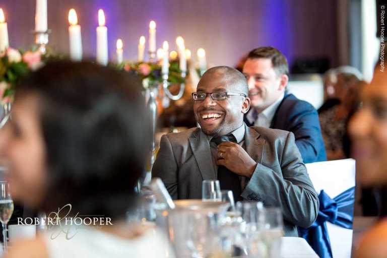 Guests laughing at speeches at wedding breakfast at Farleigh Golf Club Warlingham Surrey