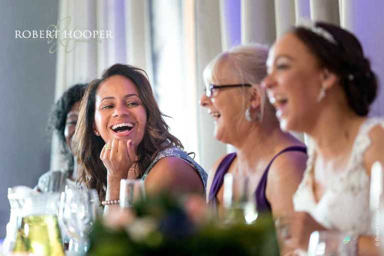 Guests laughing at speeches at wedding breakfast at Farleigh Golf Club Warlingham Surrey