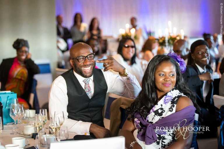 Guests laughing at speeches at wedding breakfast at Farleigh Golf Club Warlingham Surrey