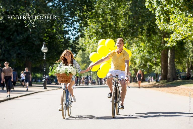 Pre wedding couple riding bikes in Hyde Park London